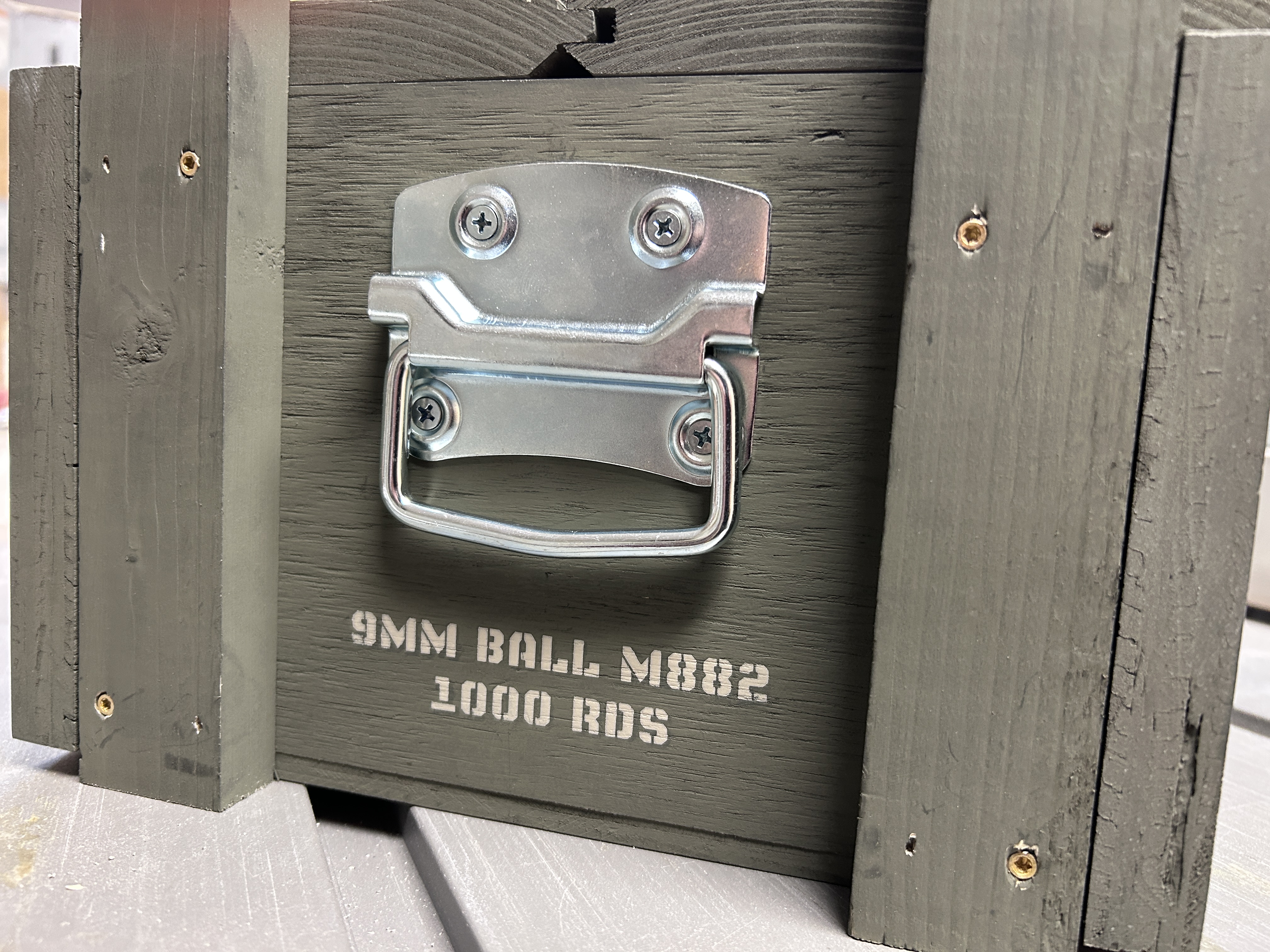 Close-up view of stainless steel D-ring handle and 9mm Ball M882 stencil