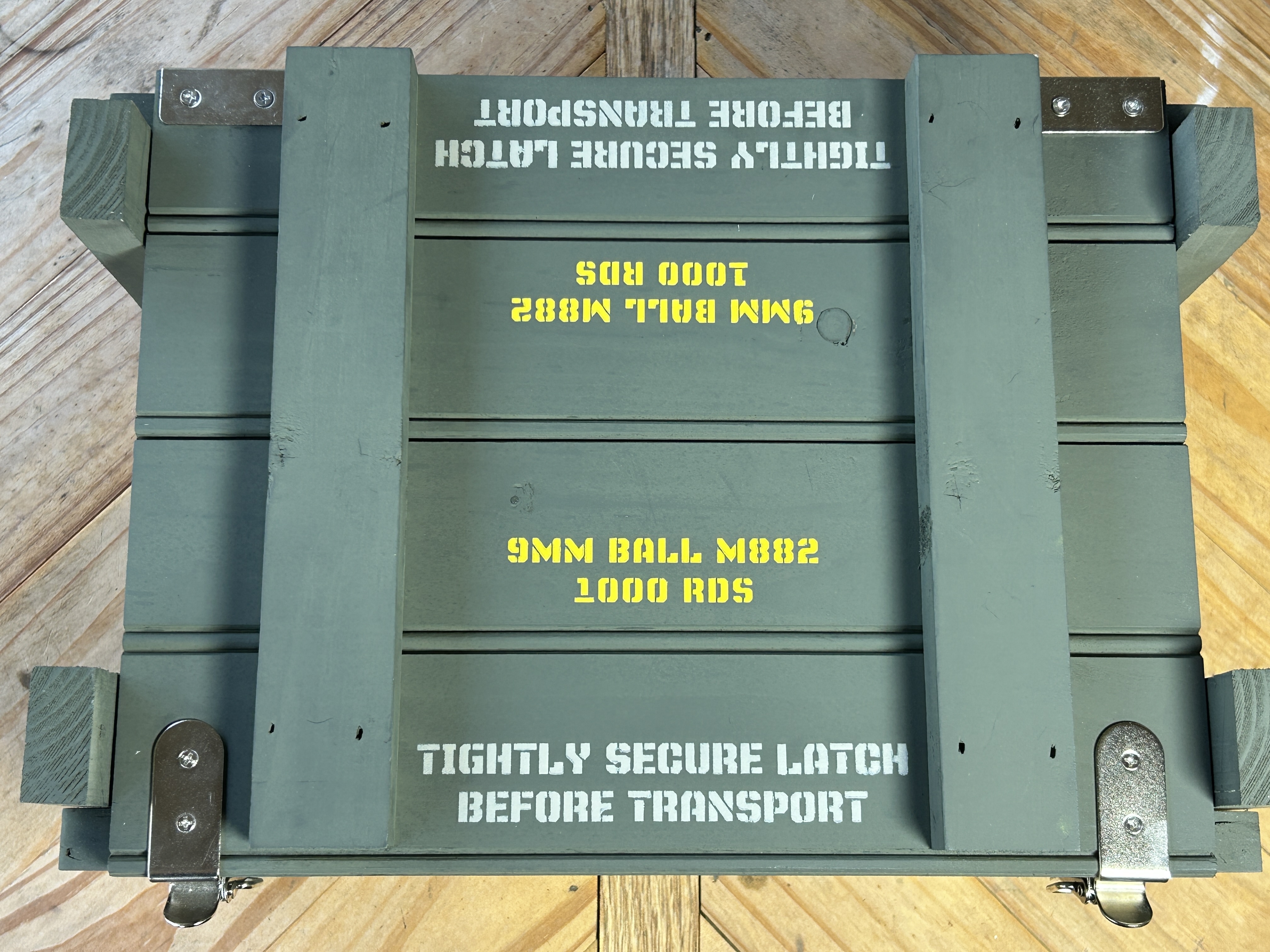 Top-down view of Caliber Collection crate with stainless hardware and lid stencil text