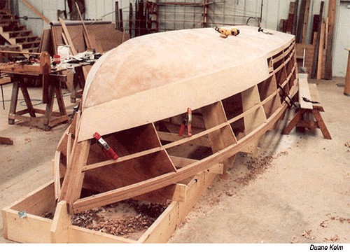 Plywood boat hull under construction in a workshop