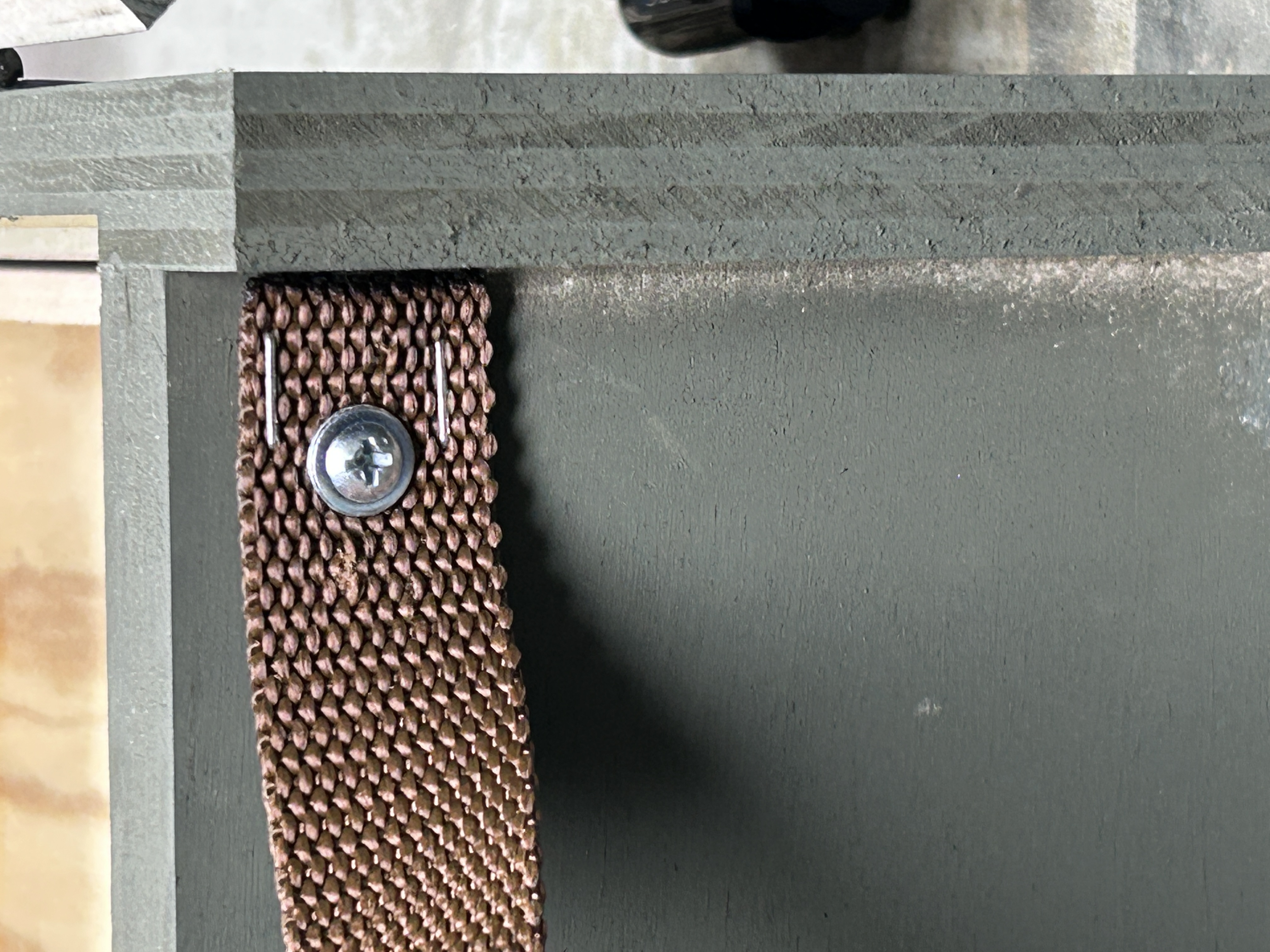 Internal coarse-thread screw anchoring nylon webbing under leg